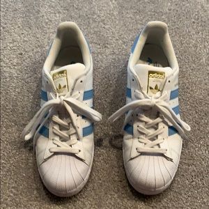 White Adidas superstars with blue stripes